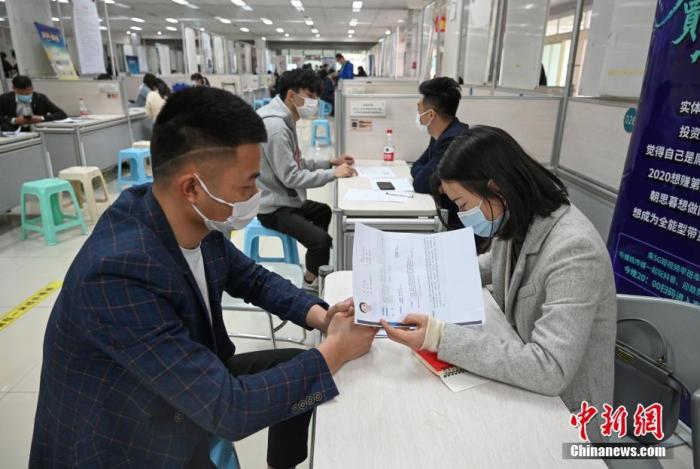 4月14日，招聘者在查看求職者簡歷。<a target='_blank'  data-cke-saved- >中新社</a>記者 王剛 攝