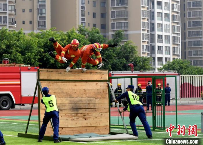 新消防員進(jìn)行消防障礙接力操展示?！⒅铱?攝