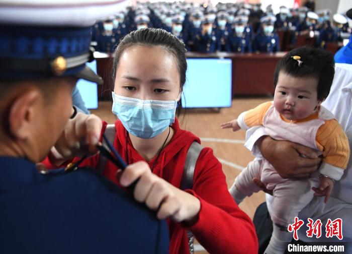 新消防員楊振的妻子彭莉與女兒現(xiàn)場(chǎng)見證丈夫加入“火焰藍(lán)”的神圣時(shí)刻。　劉忠俊 攝