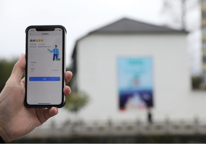 在浙江省杭州市臨安區(qū)天目山鎮(zhèn)，一名居民在“杭州健康碼”海報上掃碼申領個人二維碼。新華社發(fā)