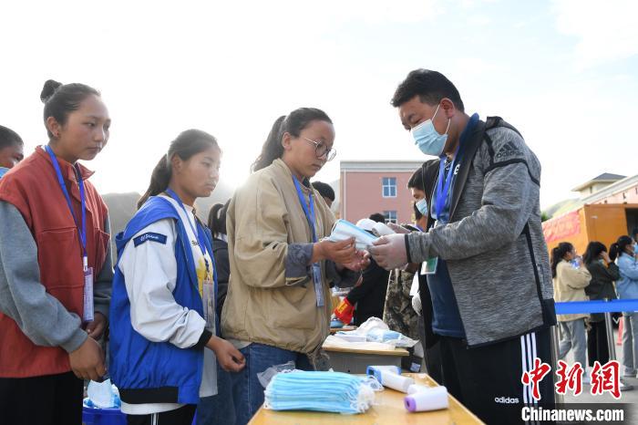 7月7日，考生在拉薩三高考點(diǎn)外領(lǐng)取口罩?！『闻罾?攝