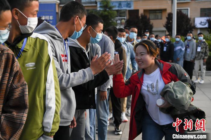 7月7日，拉薩三高考點(diǎn)外，領(lǐng)隊(duì)老師與考生擊掌鼓勁加油?！『闻罾?攝