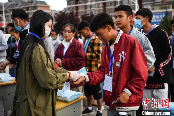 7月7日，考生在拉薩三高考點(diǎn)外測量體溫?！『闻罾?攝