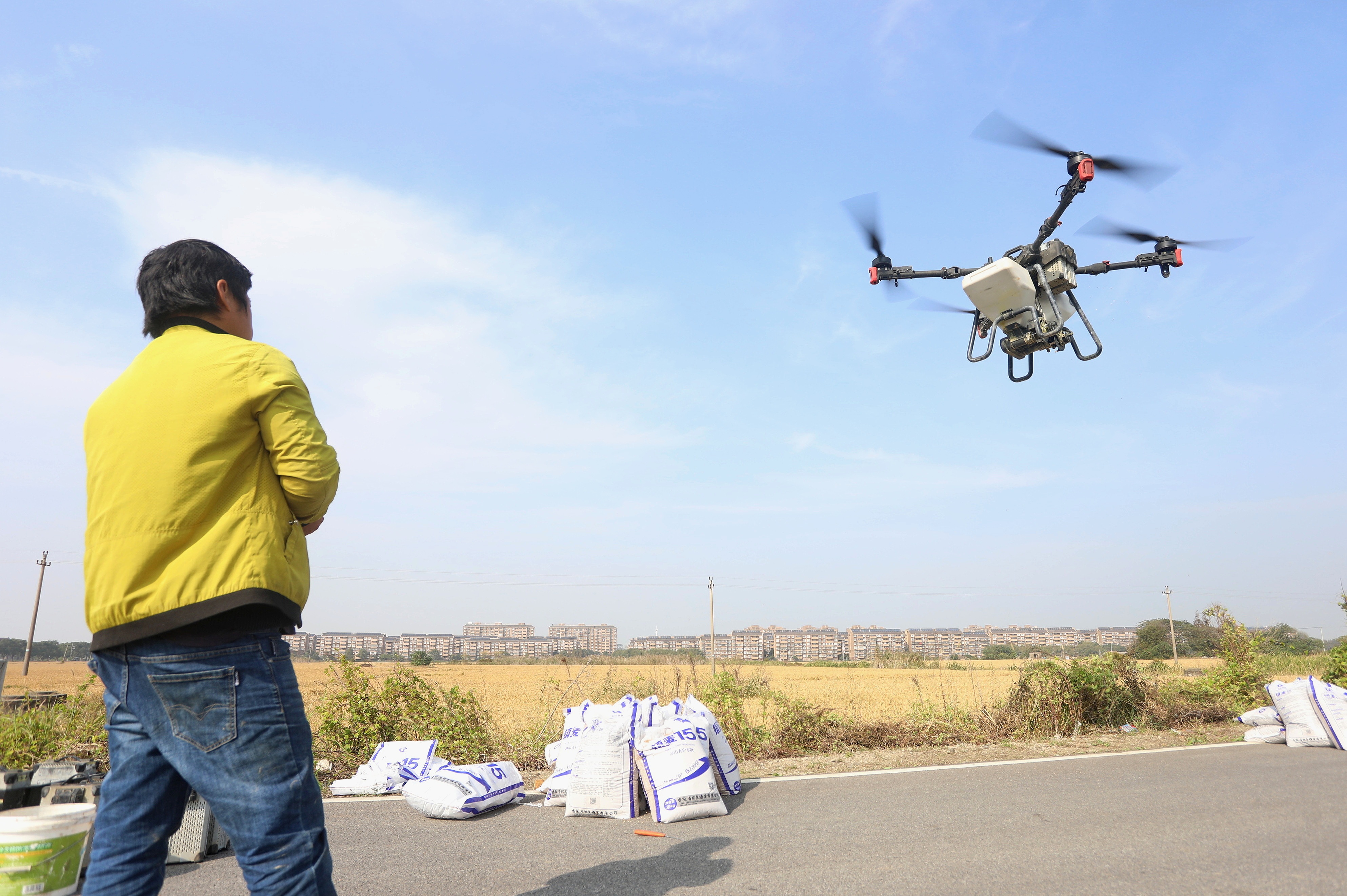 2023年11月15日，浙江嘉興，南湖區(qū)七星街道一處農(nóng)田里，農(nóng)民操縱無人機進行冬小麥飛播。